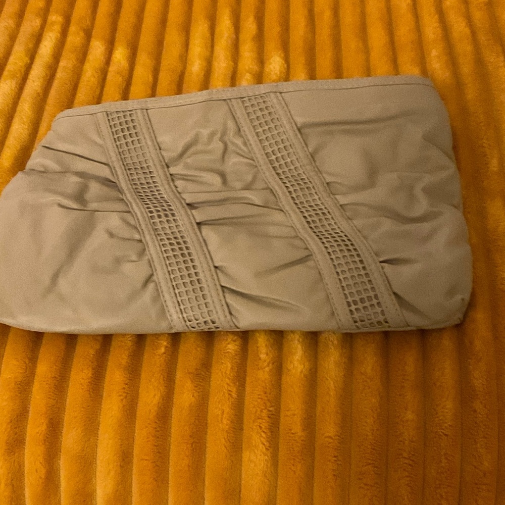 BEIGE CLUTCH BAG WITH DECORATIVE FRONT DETAIL. FAUX LEATHER